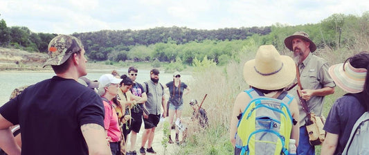 A foraging class outside, with assorted people watching the instructor
